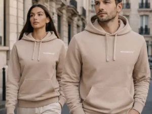 Man and woman wearing Mainbeste Sand Gold hoodies in a Parisian street